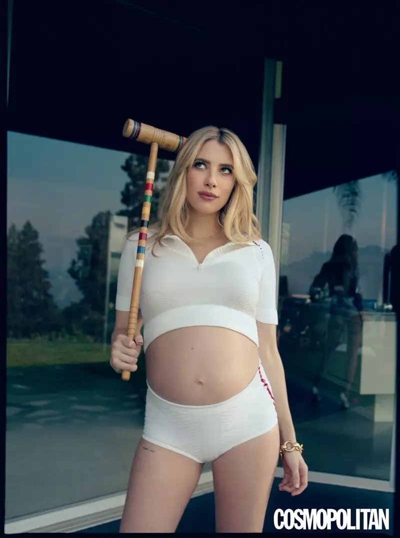 Posant avec un maillet de croquet, Emma Roberts porte une chemise et un short Prada avec un bracelet Laura Lombardi.