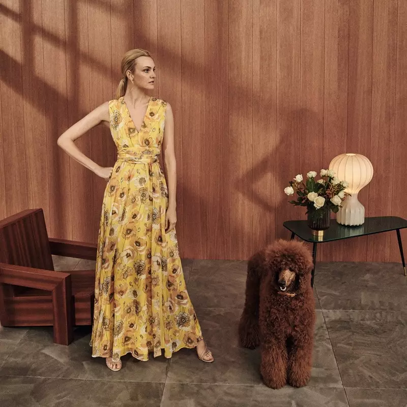 Modele Caroline Trentini pozē Max Mara kleitā ar ziedu rakstu.