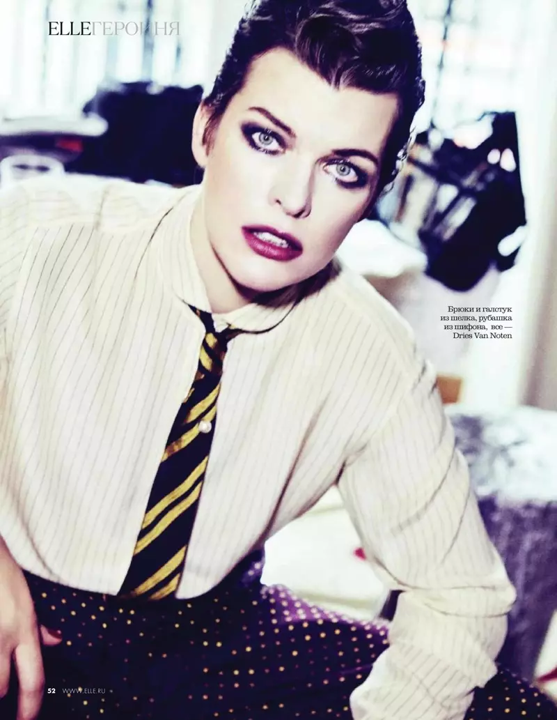 Milla Jovovich posant amb un look inspirat en roba d'home, porta camisa, corbata i pantalons Dries Van Noten