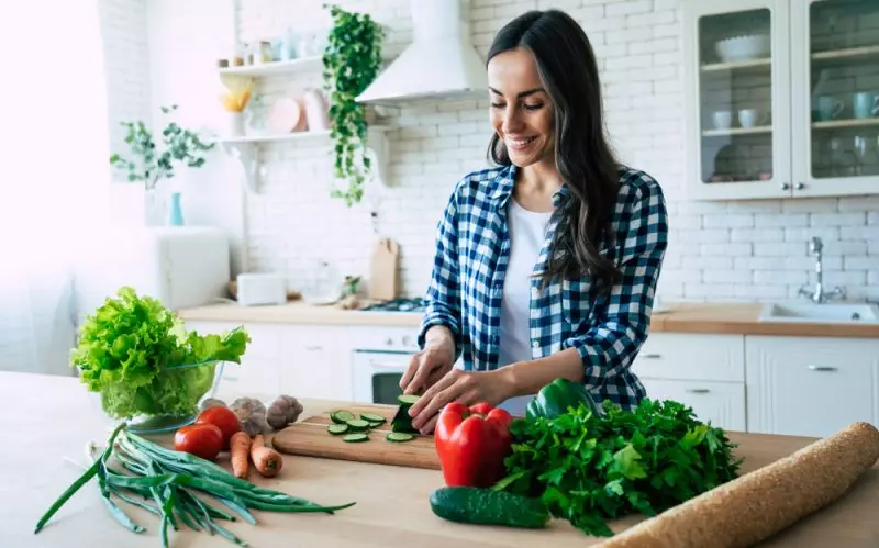 Kvinde i køkkenet laver sund mad