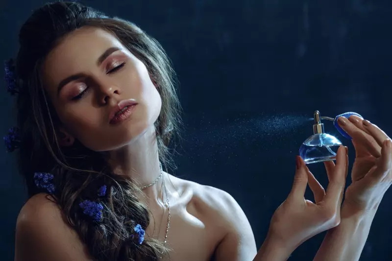 Beauty Model Spraying Perfume Blue Bottle