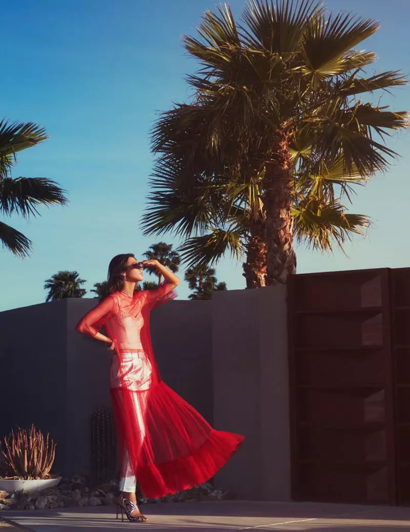 Hvatajući povjetarac, brineta model nosi prozirnu crvenu haljinu