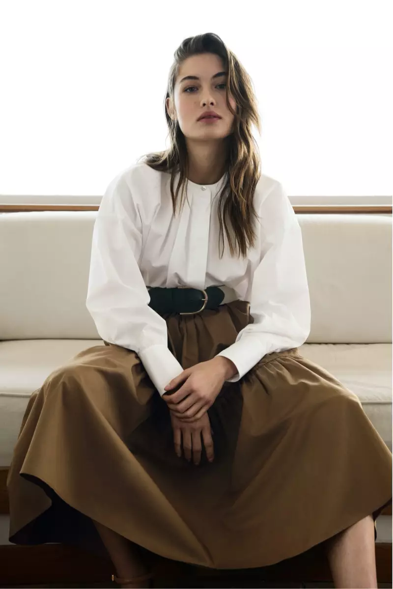 Grace Elizabeth kirasê pembû yê Massimo Dutti bi bişkokên kefçeyê û kirasê pembûyê yên neyeksanî yên poplin model dike.