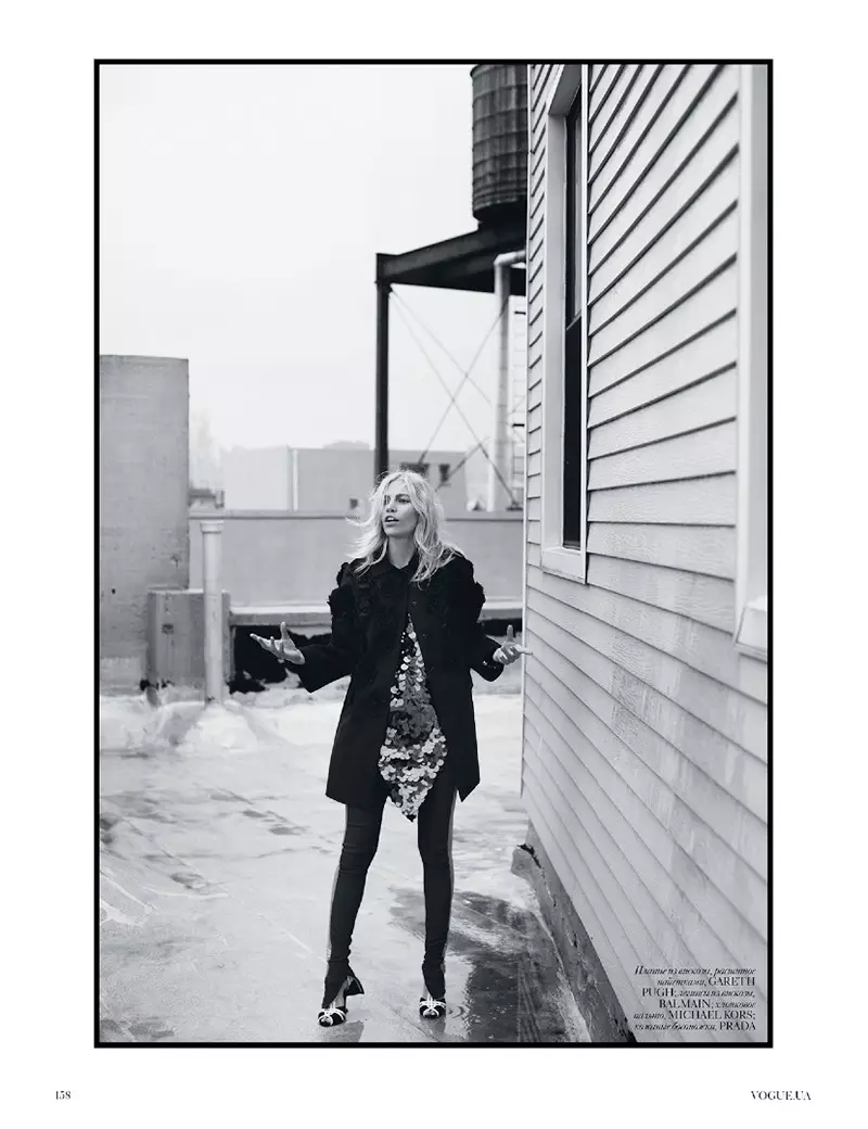Fotografata in bianco e nero, Aline posa in cappotto con abito corto