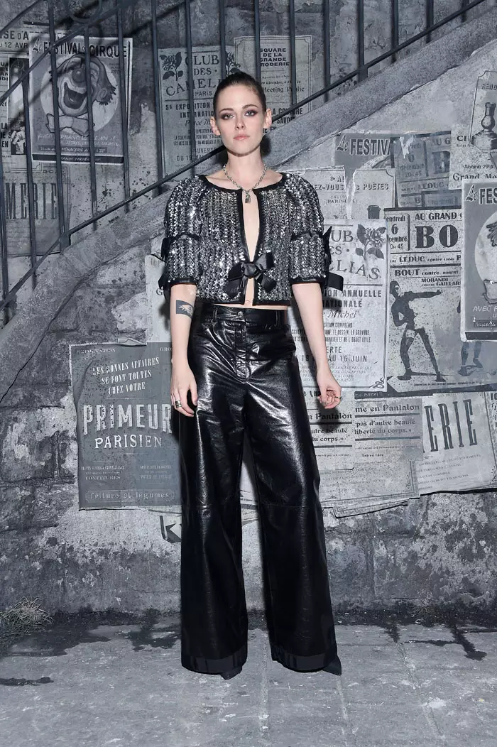 Kristen Stewart „Chanel“ parodoje „Metiers d’Art“ 2016 m. rudenį prieš rudenį Romoje vilkėjo sidabro spalvos viršutinę dalį ir juodas kelnes. Nuotrauka: „Chanel“ sutikimas