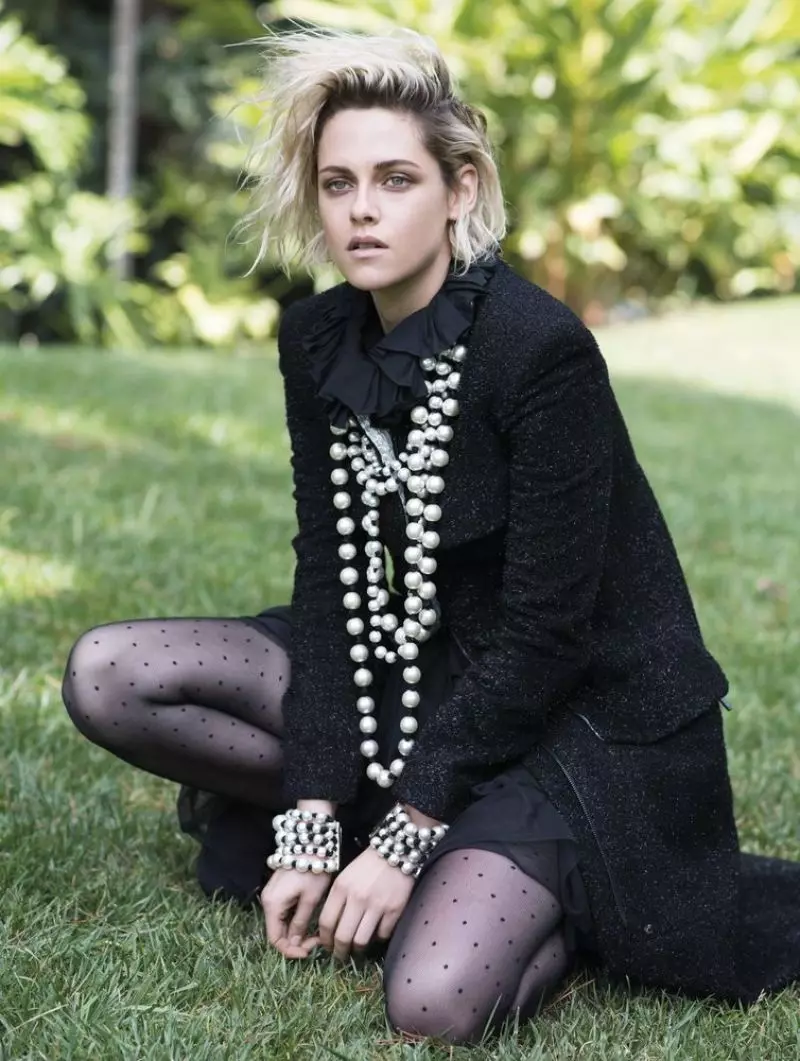 Kristen Stewart memakai jaket tweed Chanel dan kalung mutiara dengan gelang yang serasi