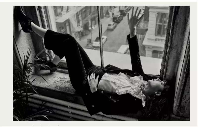 Fotografada en branco e negro, Dakota Johnson descansa cunha chaqueta e pantalóns de Giorgio Armani con top e broche de Gucci