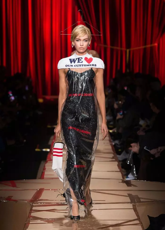 اسٽيلا ميڪسويل 2017 جي Moschino جي زوال-سياري جي مجموعن مان لانڊروميٽ بيگ ۽ هينگر سان ڍڪيل ڪارو لباس پائيندو آهي