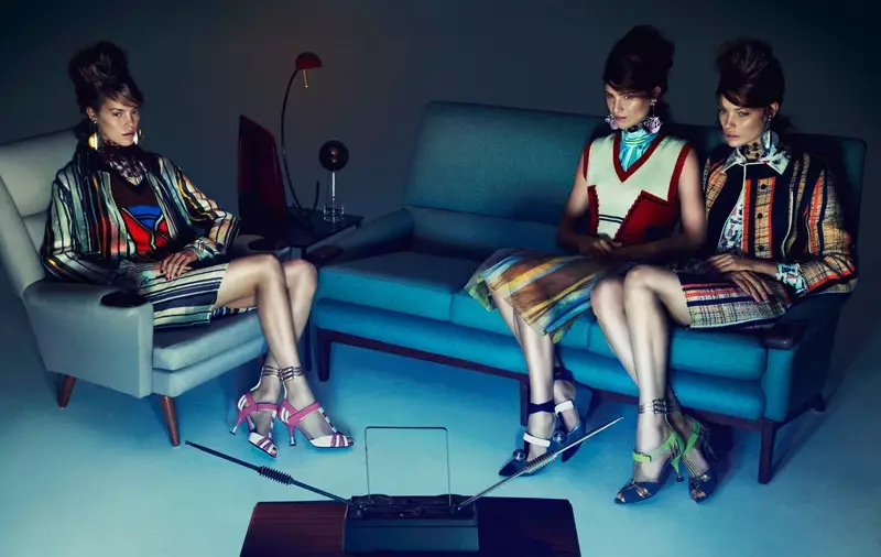 Mallit poseeraavat sohvilla ja näyttävät tyylikkäiltä Prada-kokonaisuuksissa, joissa on minihameet ja villapaitaliivit
