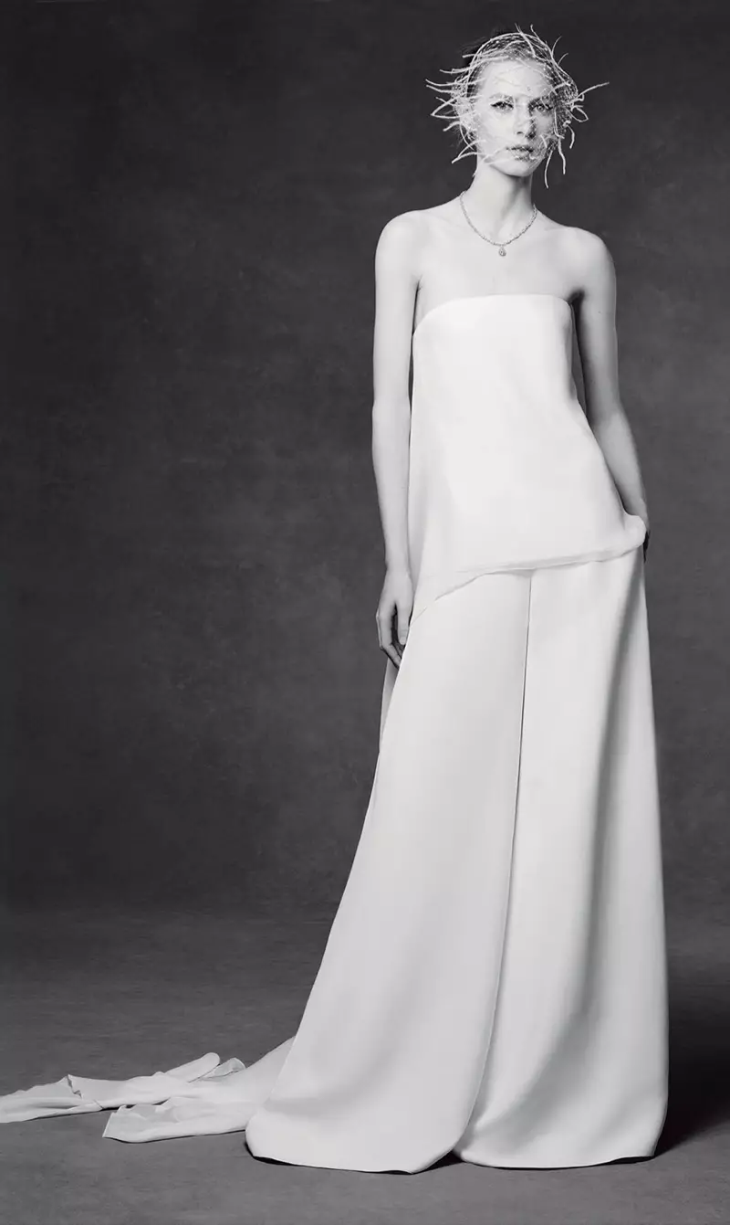 Модель Tiffany & Co зергерлік бұйымдарын киіп, ақ комбинезонмен торлы маскада суретке түседі.