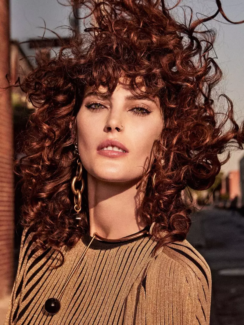 Coiffée d'une coiffure frisée, Catherine McNeil pose en robe Sonia Rykiel avec boucles d'oreilles Marni