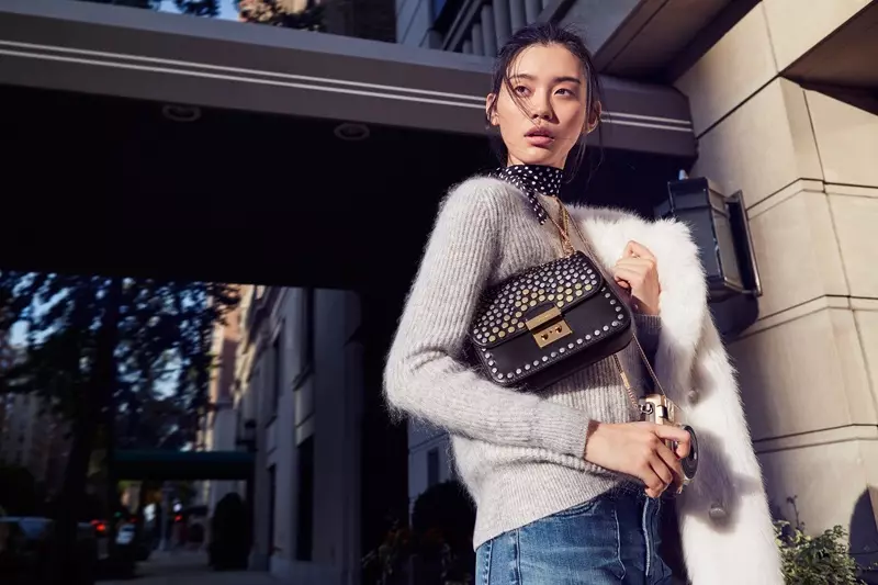 Modelis Ming Xi pozuoja su Michaelo Korso „Sloan Editor“ krepšiu