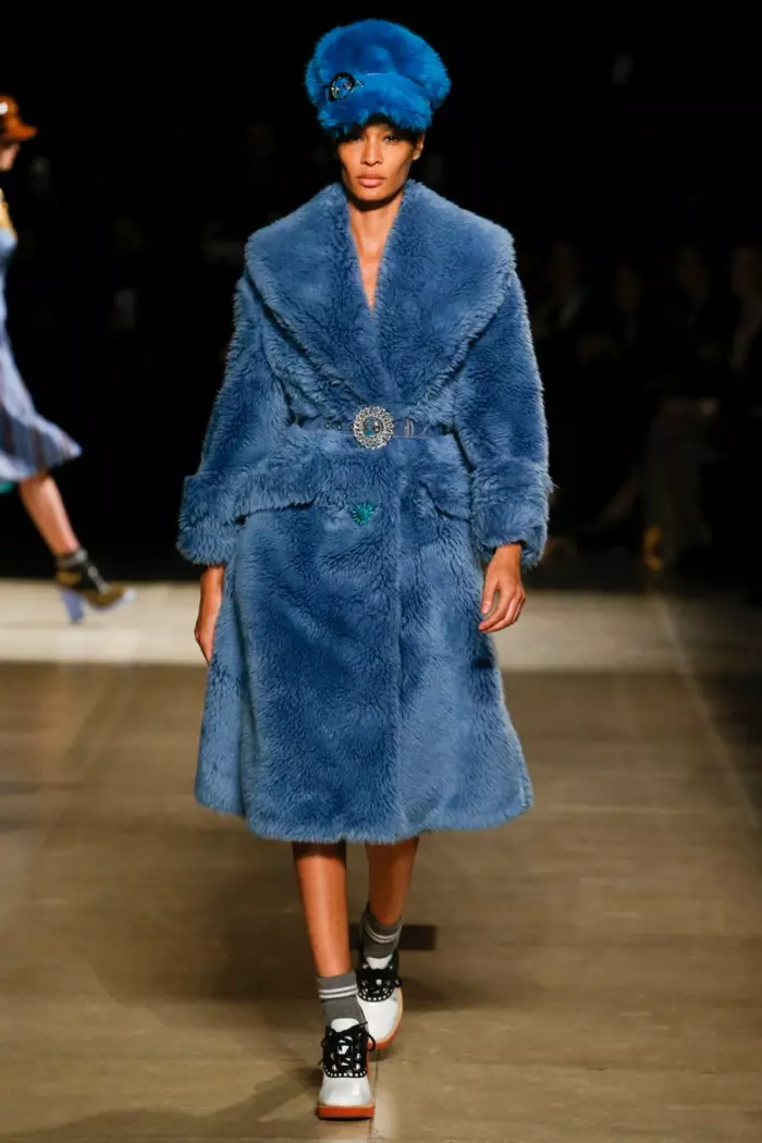 Joan Smalls trägt eine blaue Pelzmütze und einen Mantel mit kristallverziertem Gürtel aus der Herbst-Winter-Kollektion 2017 von Miu Miu