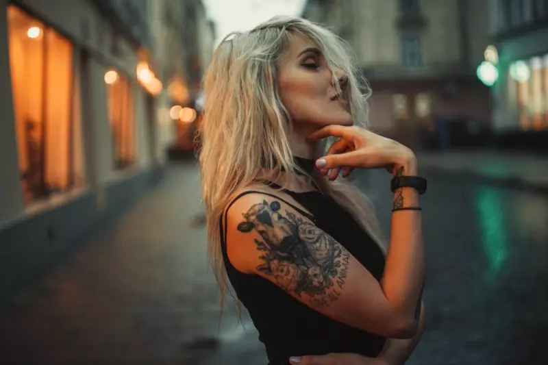Braccio tatuaggio ragazza bionda all'aperto
