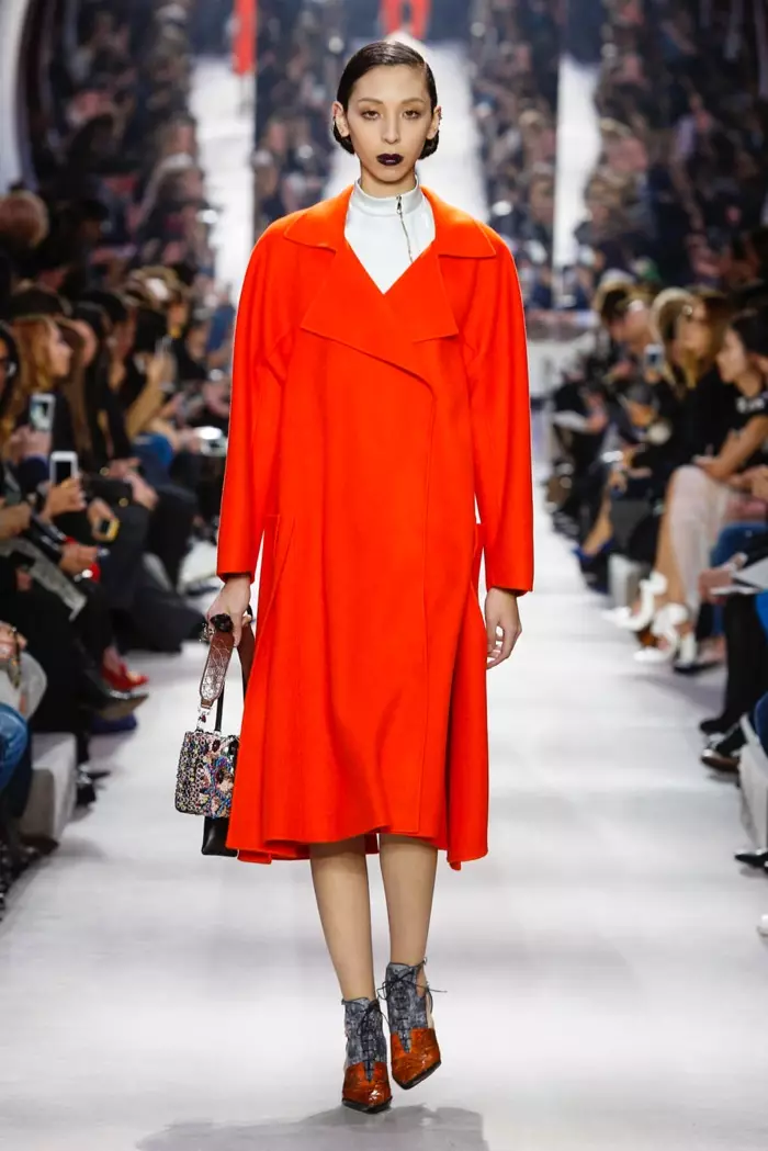 Un mannequin porte un manteau rouge au défilé Dior automne-hiver 2016