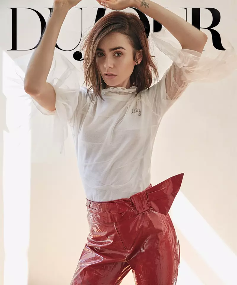 Per dare un tocco in più al suo look, Lily Collins indossa una camicia Burberry con colletto a volant e pantaloni rossi Isabel Marant