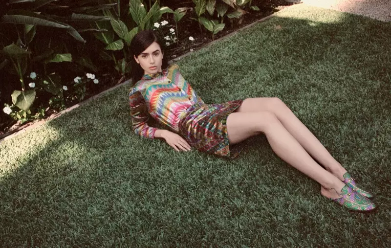 Allongée dans l'herbe, Lily Collins pose en blouse et jupe Missoni avec des mocassins Gucci