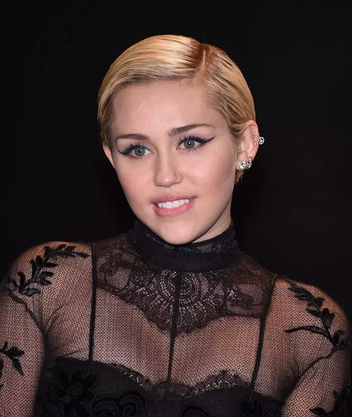 Ĉe okazaĵo por Tom Ford, (2015) Miley Cyrus portis mallongan blondulinhararon kun flankparto. Foto: DFree / Shutterstock.com