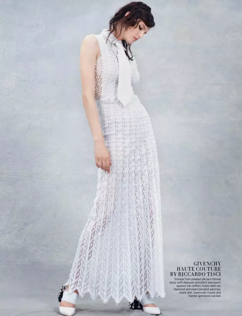Izskatoties eleganti baltā, modele pozē kroku zīda mežģīņu kleitā no Givenchy Haute Couture