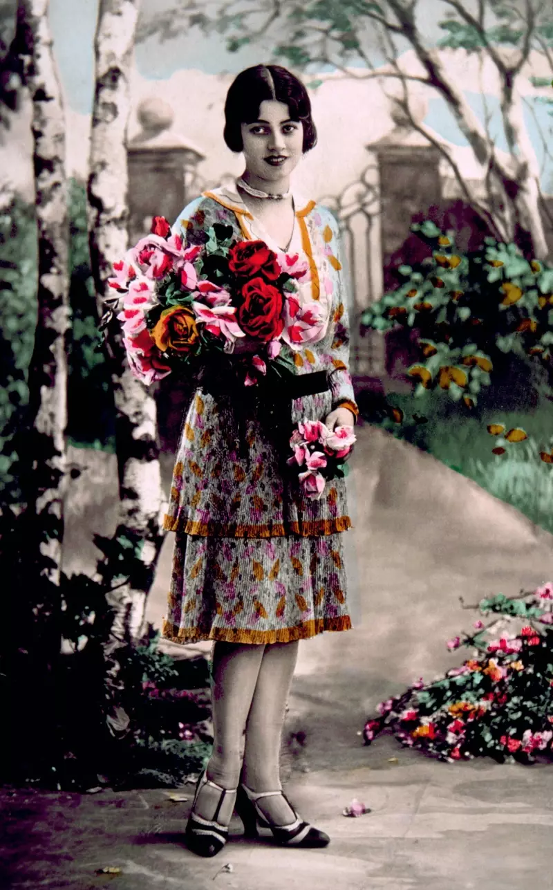 Ova slika u boji prikazuje ženu iz 1920-ih u haljini s preklopom.