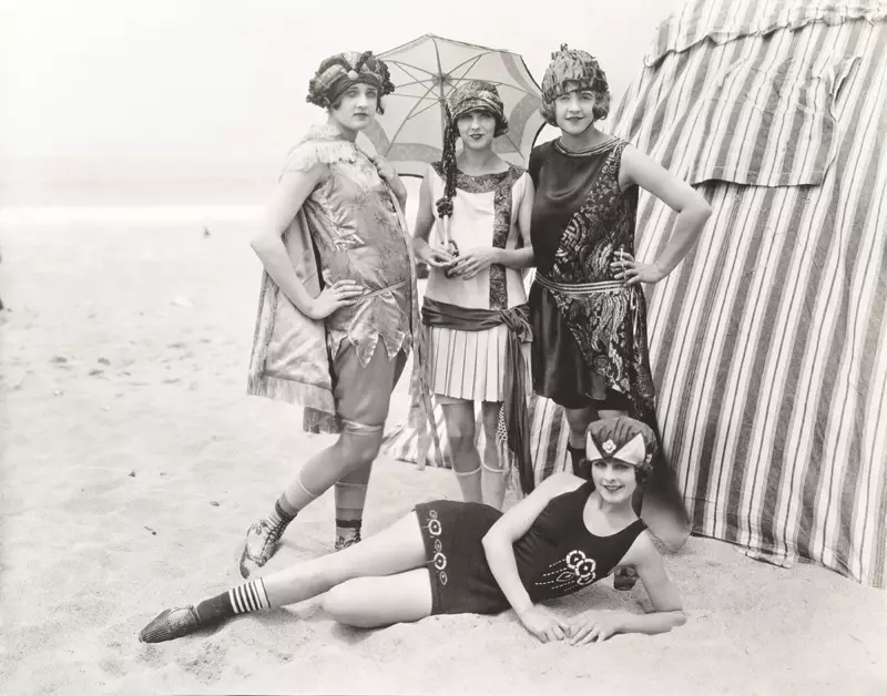 Virinoj pozas en lanaj naĝkostumoj ĉe la strando en la 1920-aj jaroj. Foto: Shutterstock.com