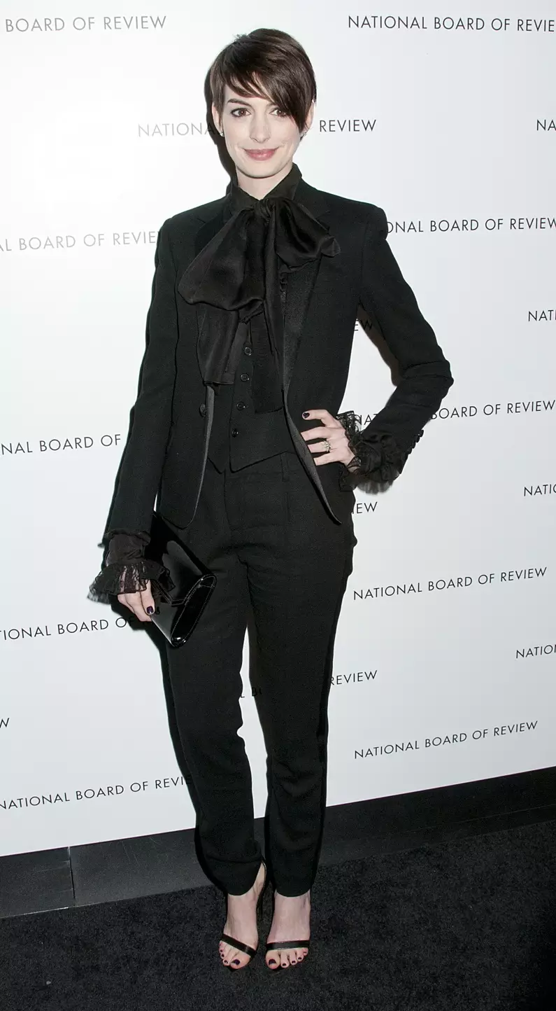 Anne Hathaway amevalia suti ya suruali ya tuxedo ya Saint Laurent yenye shati nyeusi iliyokatika. Picha: Janet Mayer / PRPhotos.com