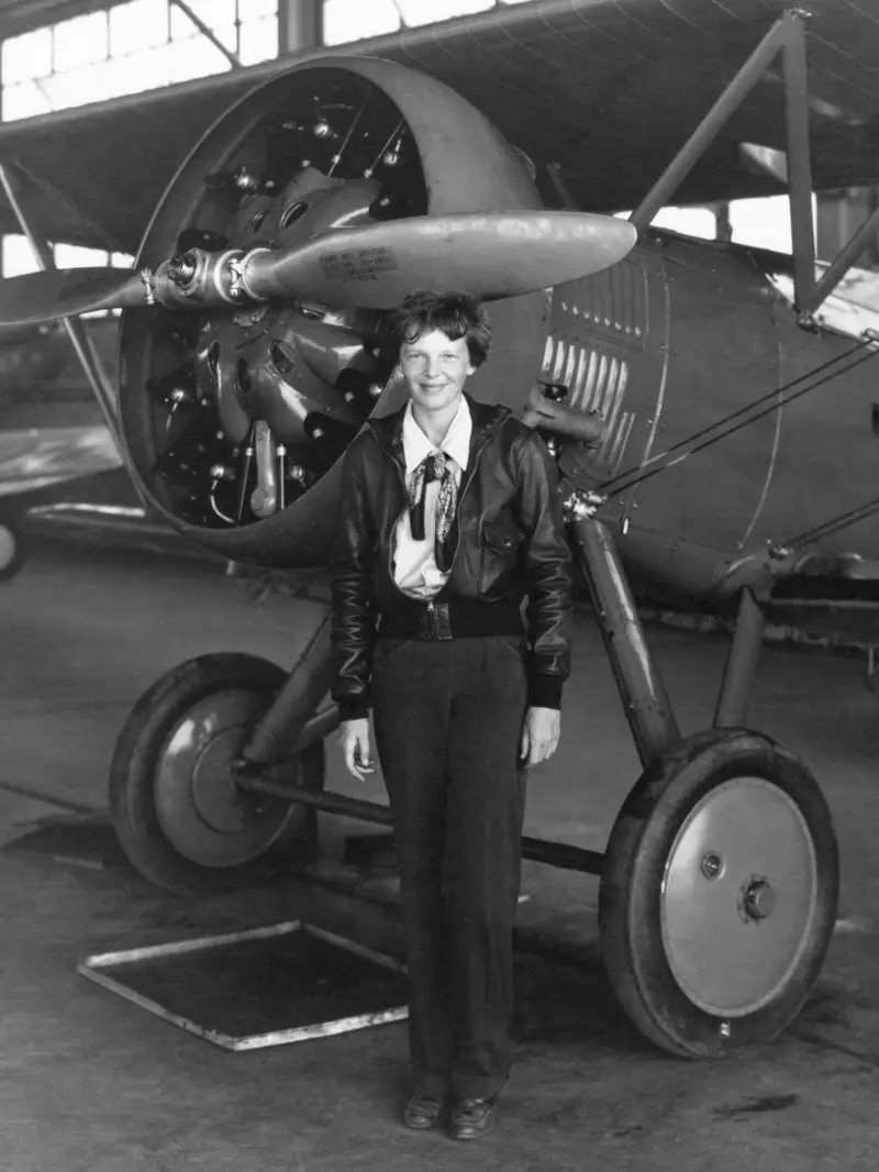 Penerbang Amelia Earhart memakai seluar dalam gambar 1936 sambil bergambar di sebelah kapal terbang. Foto: Shutterstock.com