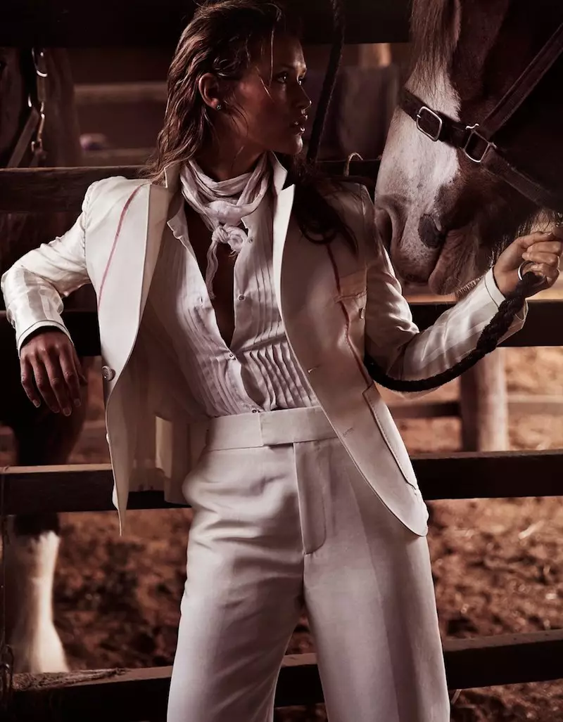 Poserend naast een paard, past het model in Bally jas en broek met Karen Walker geplooid shirt