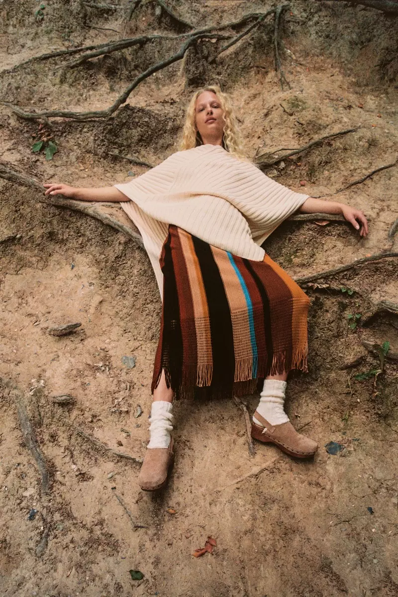 Frederikke Sofie modele pelerina lungă asimetrică Zara, fustă din tricot cu dungi și saboți din piele despicată.