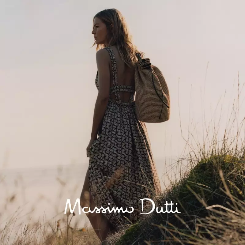 Vestido longo com estampa geométrica Massimo Dutti, sandália rasa de couro com amarração e bolsa transversal de ráfia com detalhes em couro.