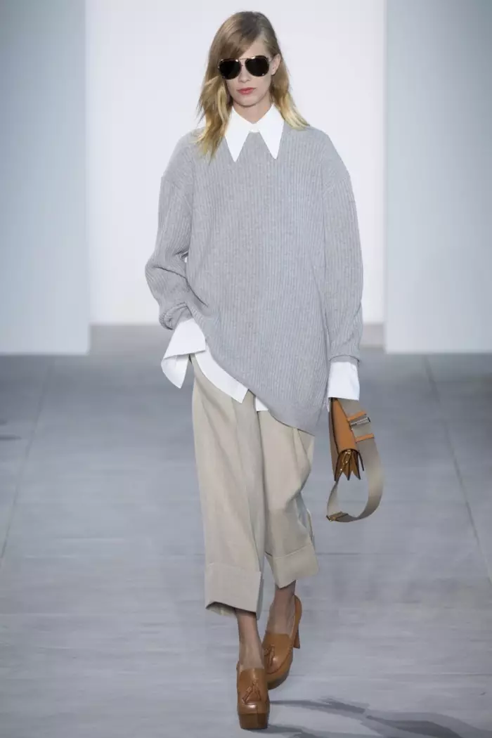 Michael Kors Primavera 2017: Lexi Boling camina per la passarel·la amb un jersei gran gran gris, camisa blanca i pantalons curts