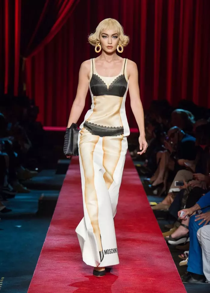 Moschino Spring 2017: Gigi Hadid naglakaw sa runway nga nagsul-ob og sinina nga nagpakita sa papel nga monyeka nga print nga adunay bra ug underwear