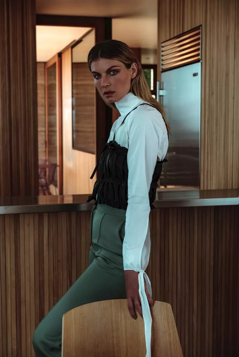 Modelo Angela Lindvall posa com blusa manga longa com top translúcido e calça de cintura alta