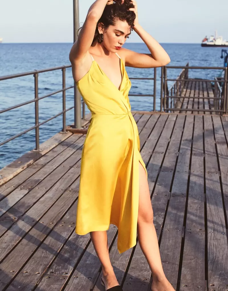A sárga árnyalatait ölelő modell Victoria Beckham ruhát és Aurelie Bidermann fülbevalót visel