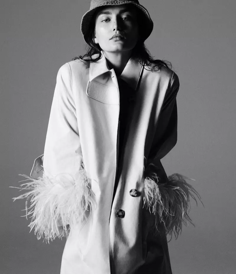 Le mannequin Andreea Diaconu pose dans un trench-coat Prada avec un chapeau House of Lafayette