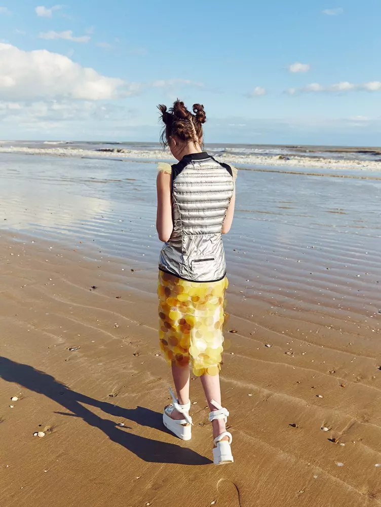 Nakasuot ng platform shoes--isang trademark ng raver style--naglalakad ang modelo sa beach