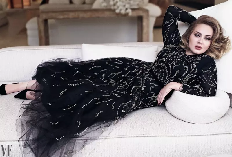 La cantante Adele se recuesta en un sofá con un vestido adornado