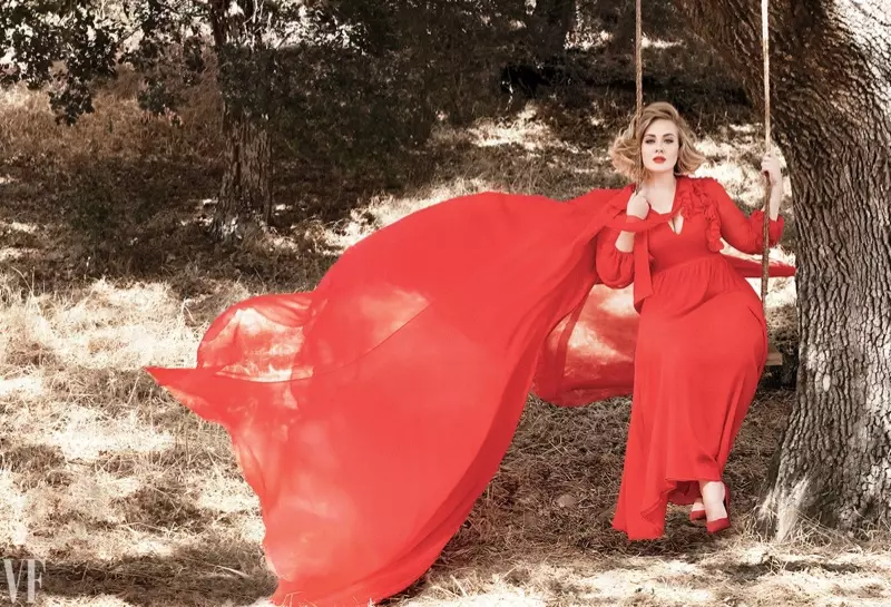 阿黛尔在一棵橡树下摆姿势，身穿红色斗篷和连衣裙