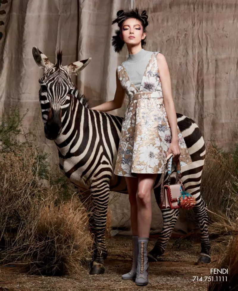 Zebra baten ondoan zutik, Fei Fei Sun-ek Fendi soinekoa, poltsa eta parpaildun botak modelatzen ditu