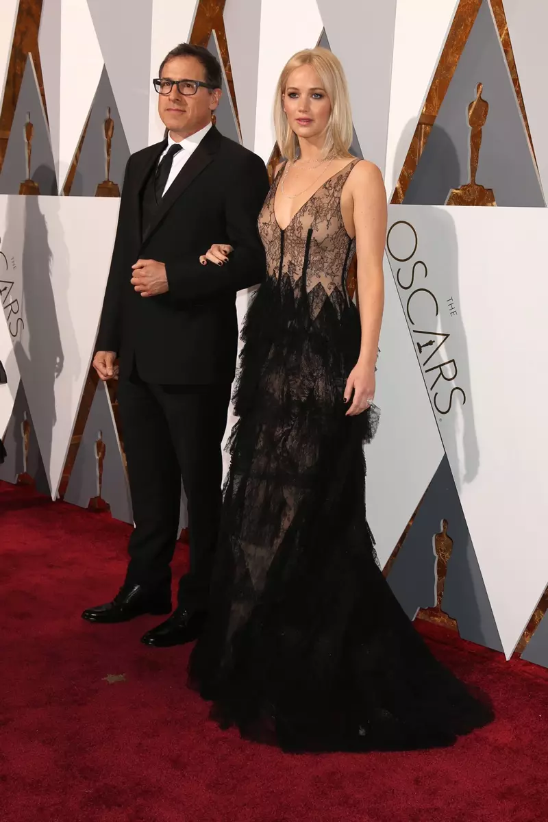 OSCARS 2016 STYLE: Jennifer Lawrence yitabiriye ibihembo bya 88 bya Academy hamwe numuyobozi David O'Russell yambaye ikanzu yumukara Dior. Ifoto: Helga Esteb / Shutterstock.com