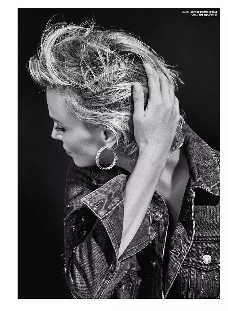 Difoto dalam warna hitam dan putih, Charlize mengenakan jaket denim Givenchy by Riccardo Tisci