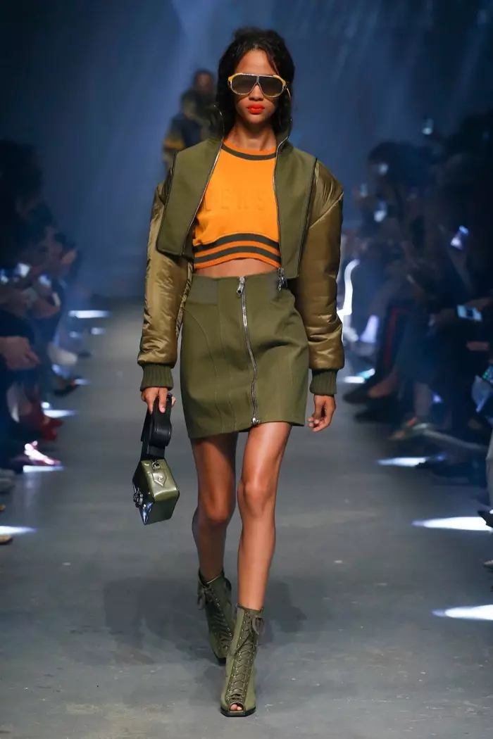 Versus Versace Spring 2017: Model mlaku ing landasan pacu nganggo jaket bomber sing dipotong, top crop bermerek lan rok mini kanthi detail zipper