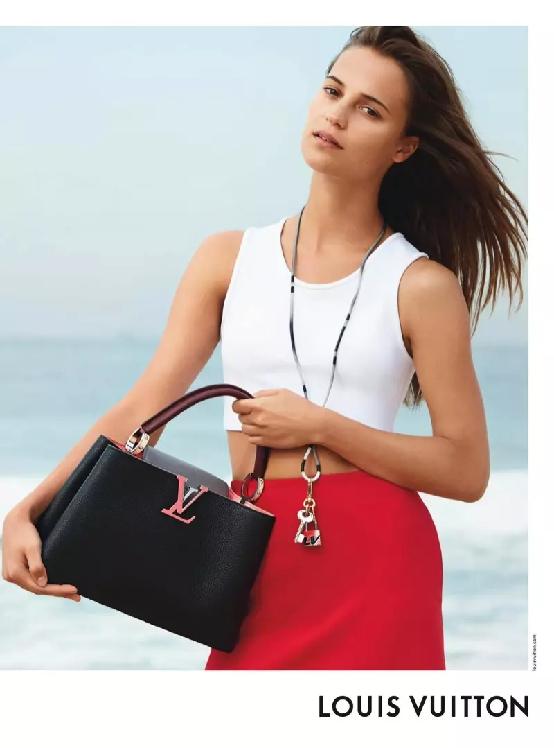 Alicia Vikander posiert am Strand und modelliert die Capucines PM-Tasche von Louis Vuitton