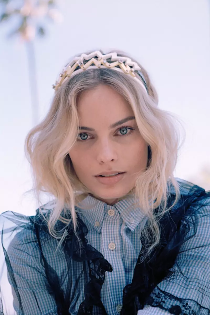 Með ljósa hárið í áhyggjulausum bylgjum klæðist Margot Robbie Miu Miu skyrtu, kjól og skreyttum hárböndum