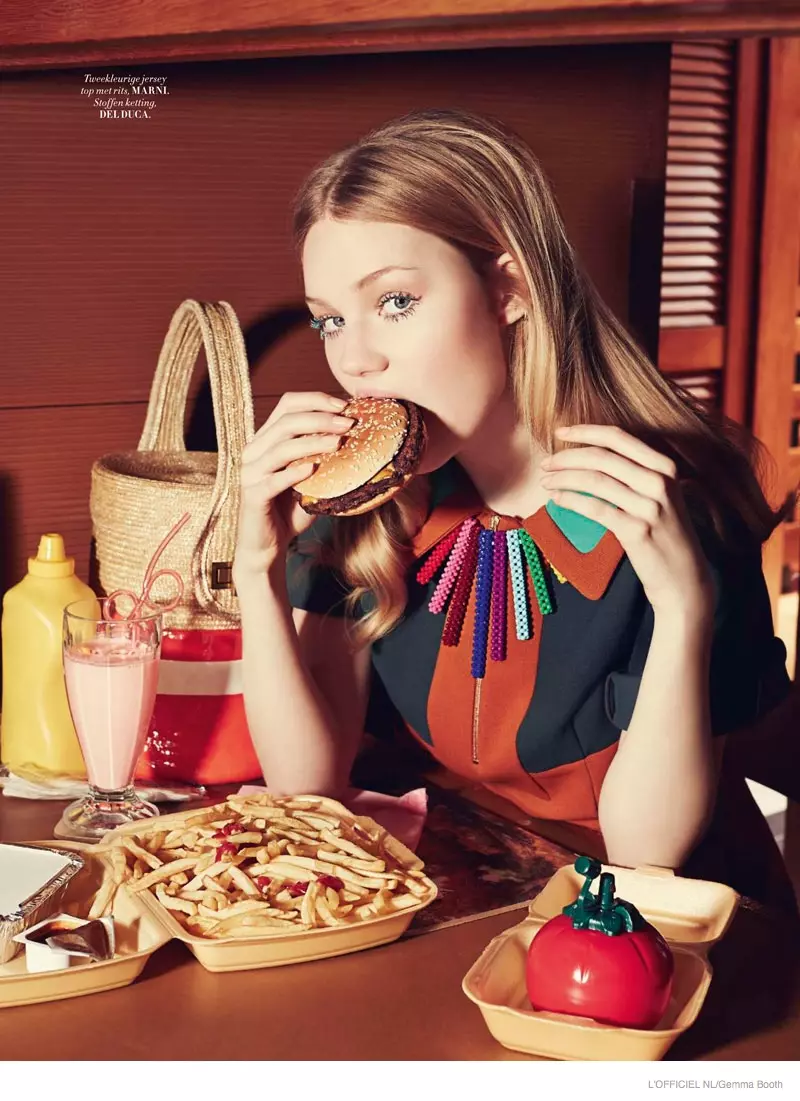 Zanna eet een hamburger terwijl ze een kleurrijke Marni-jurk en Del Duca-halsketting modelleert.