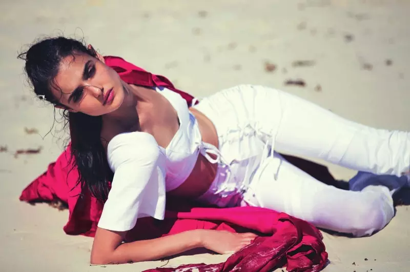 Ant smėlio pozuojanti „Blanca Padilla“ modelių Haider Ackermann paltas su „Diesel Black Gold crop top“ ir džinsais