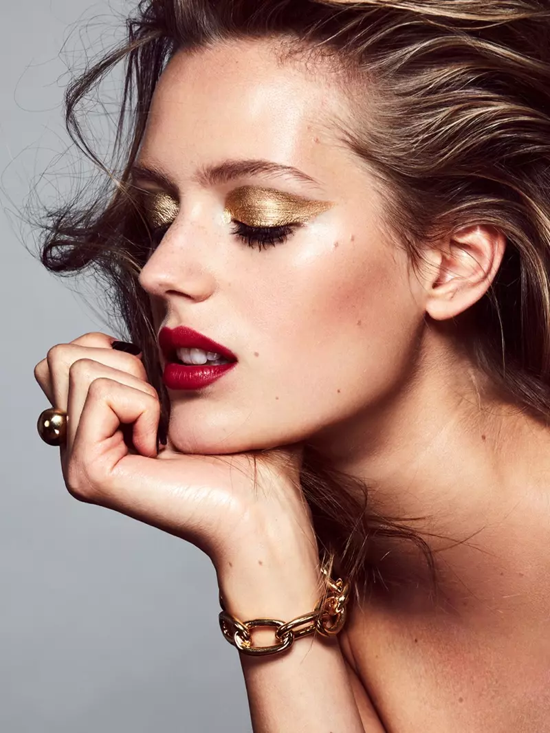 It model skynt mei gouden eachskaad en reade lippenstift