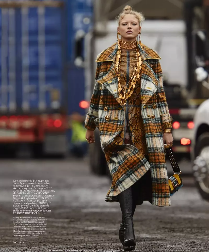 Martha Hunt fè yon pwomnad nan rad lenn mohair, rad ak valiz nan men Burberry ak bòt Givenchy.