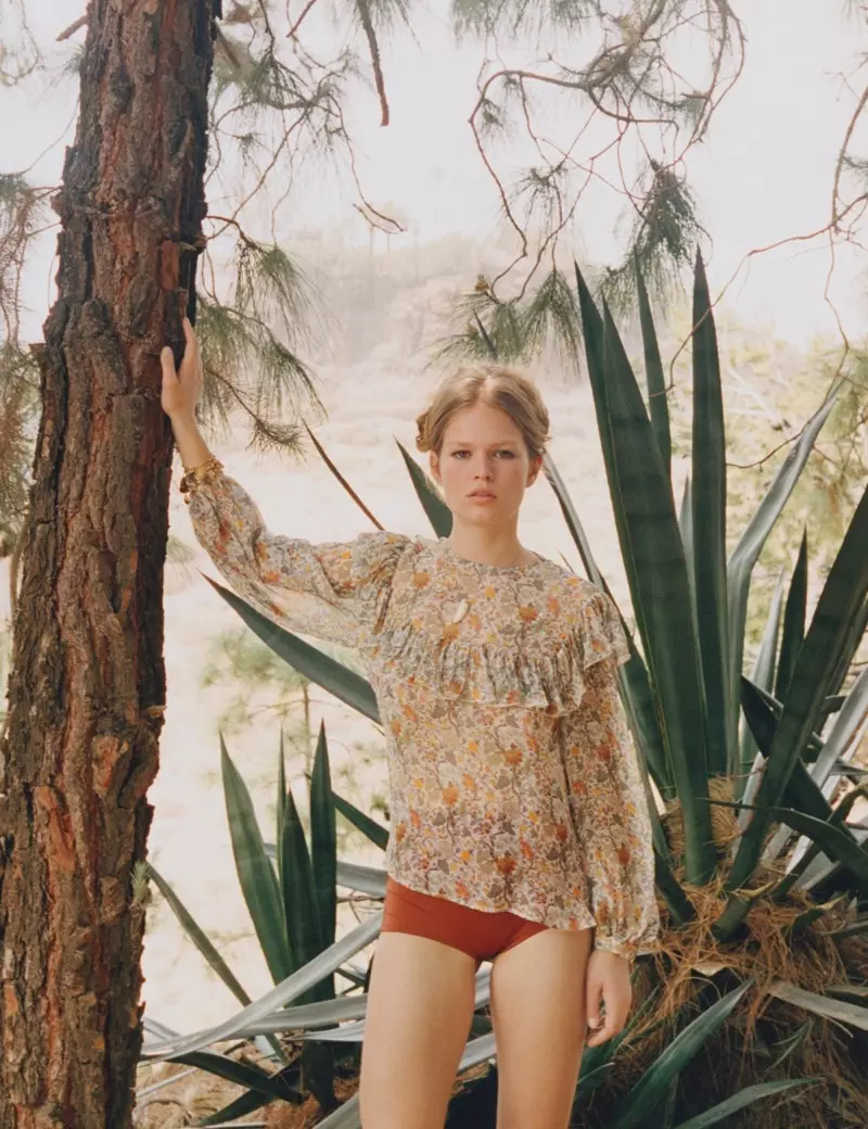 Anna Ewers situr fyrir í Karen Walker toppi með gegnheilum og röndóttum bikiníbotni.