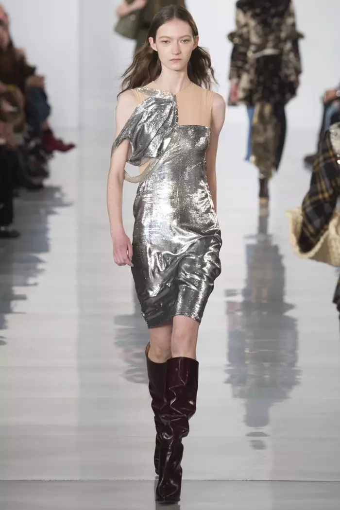 Загвар өмсөгч 2016 оны намар-өвлийн Maison Margiela шоуны үеэр өвдөг хүртэл өндөр гуталтай мөнгөн даашинз өмсөж, хөөрөх зурвасаар алхаж байна